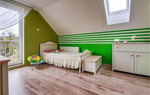 姆拉哥沃Awesome Home In Mragowo With Lake View的儿童卧室设有绿色墙壁和一张床