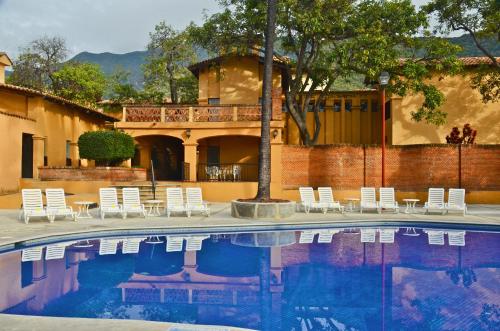 阿吉吉克丹扎德尔索尔别墅酒店的一个带白色椅子的游泳池以及一座房子