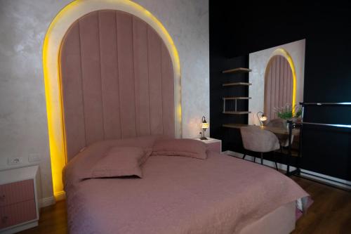 地拉那Stylish two bedroom house with private pool的一间卧室配有一张大床和拱形床头板