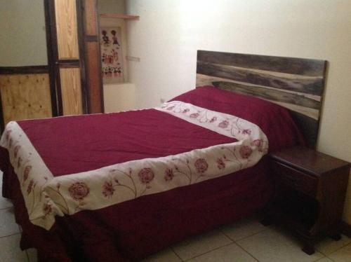 Belle Air SummitHibiscus Cottage的一间卧室配有一张红色棉被的床