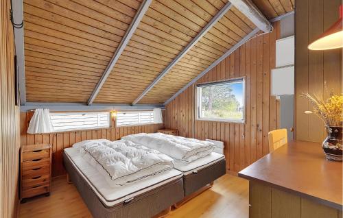 博利尔马克Amazing Home In Rm With Sauna, Wifi And 4 Bedrooms的木制客房内的一间卧室,配有一张床