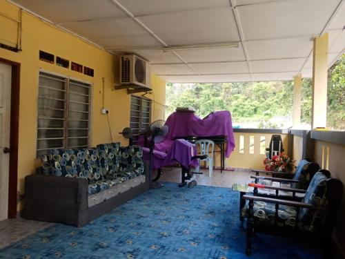 Kampong Tanjong IpohKuntum Cottage Bad & Breakfast的客厅配有沙发和桌子