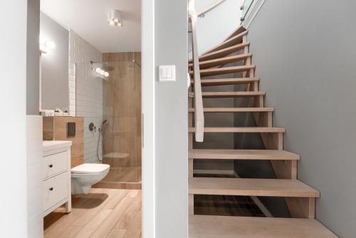 什切青EXCLUSIVE New Town Apartments的一间带楼梯的浴室和一间带卫生间的浴室