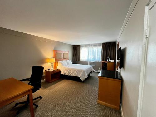 乔治王子城Anavada Inn & Suites - Prince George的配有一张床和一张书桌的酒店客房