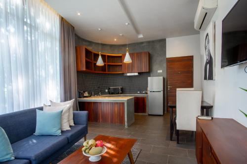 暹粒Maison Leab的一间带蓝色沙发的客厅和一间厨房