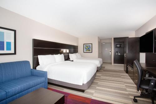 林肯市Holiday Inn Express & Suites Lincoln City, an IHG Hotel的酒店客房设有一张大床和一张蓝色的沙发。