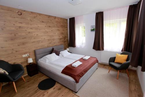 埃格尔Villa Terrasse的一间卧室配有一张床和两把椅子