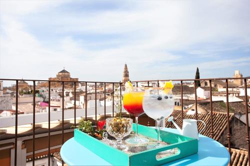 科尔多瓦玛迪娜酒店的阳台上的桌子上放着两杯饮料的托盘