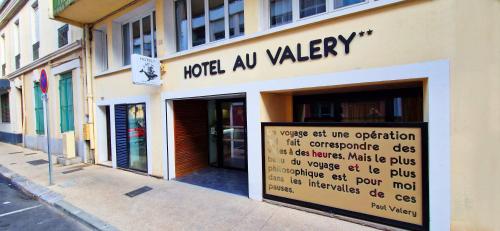 塞特港Hôtel Au Valéry的建筑物一侧有标志的商店