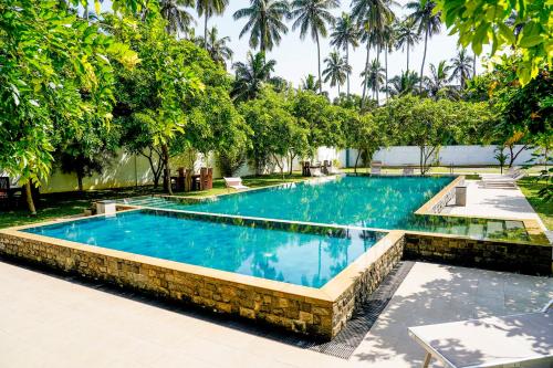 瓦伊卡尔Even Beach Resort的度假村内的一个蓝色海水游泳池