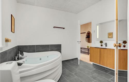 LihmeBeautiful Home In Spttrup With Wifi的浴室配有白色浴缸和水槽