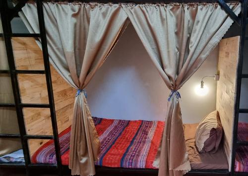 河江Rainbow House Ha Giang的床上床,带窗帘的房间