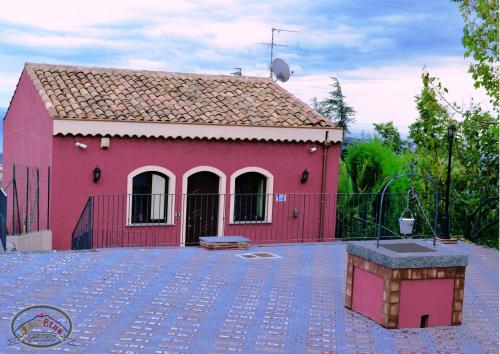 圣阿尔菲奥Agriturismo Dolcetna的一座红色的房子,有红色的栅栏和院子