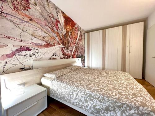 马尔切西内Due Lune Home的卧室配有一张床,墙上挂有绘画作品