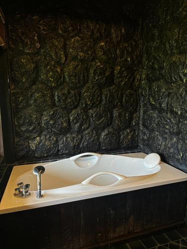 湄林班顿洛度假村 的石墙浴室内的盥洗盆