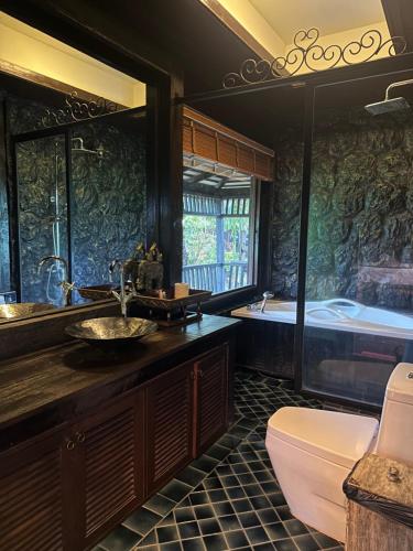 湄林班顿洛度假村 的带浴缸、盥洗盆和卫生间的浴室