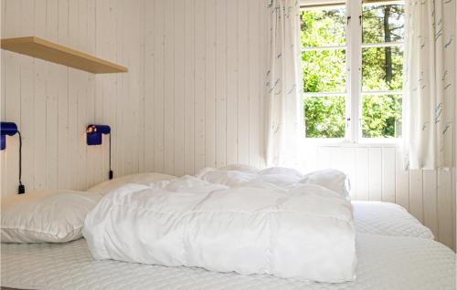维斯特索马肯3 Bedroom Stunning Home In Aakirkeby的白色的床、白色床单和窗户
