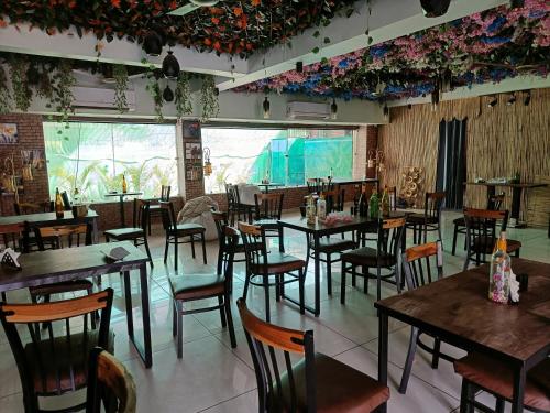 古尔冈Nearmi Hotels Banquets Medanta IKEA Sector 47 - Gurugram的餐厅设有桌椅和大窗户。