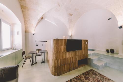 滨海波利尼亚诺Cinquevite的一间带电视和桌子的客厅