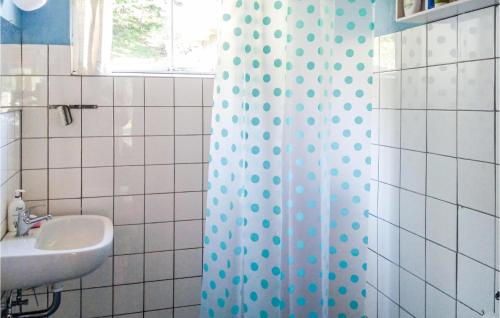Anholt3 Bedroom Lovely Home In Anholt的浴室配有淋浴帘和盥洗盆。