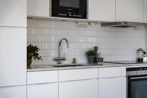 斯德哥尔摩Beautiful and modern accommodation near Stockholm City的厨房配有白色橱柜和水槽