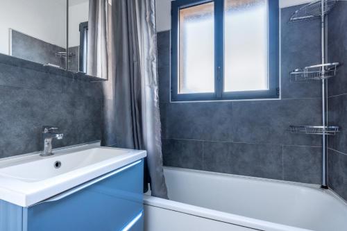 亚眠Maison Famille-Confort-Terrasse Jardin-Vue Cathédrale的一间带水槽、浴缸和淋浴的浴室