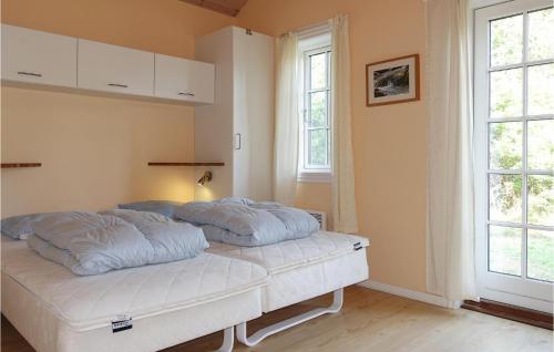 维斯特索马肯Gorgeous Home In Aakirkeby With Wifi的一张位于房间的床,上面有两个枕头