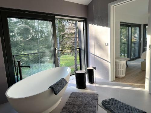 博登湖畔克雷斯波洛Park-Villen的带浴缸的浴室和大窗户