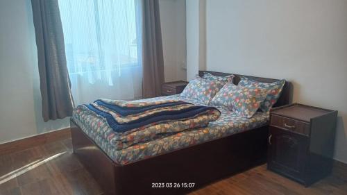 大吉岭Darjeeling Homestay Nyano Ghar的一张小床,上面有毯子,放在房间里