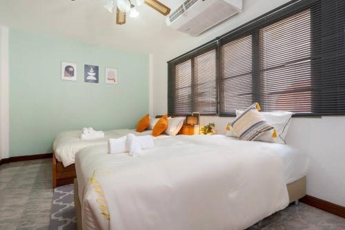 芭东海滩Solene Home Patong的卧室设有2张大型白色床和窗户