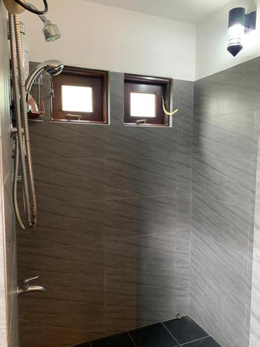本托塔Tranquil Private Villa near Bentota Beach的带淋浴的浴室和2扇窗户