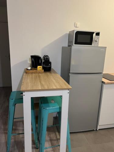 维勒帕里西Appartement idéalement placé的厨房配有带微波炉和冰箱的桌子