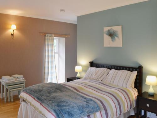 BelladrumThe Kennels Bothy - Beaufort Estate的一间卧室设有一张大床和一个窗户。