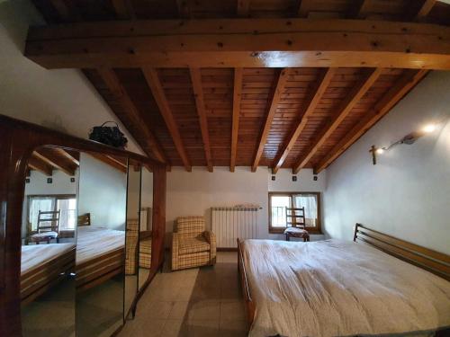 RegoledoPleasant apartment in Vendrogno with balcony的一间卧室设有一张带木制天花板的大床