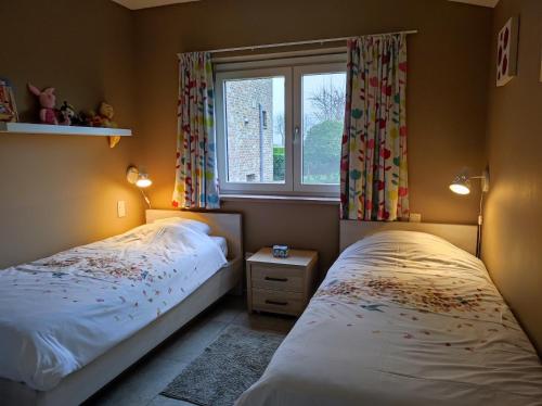 亚贝克B&B Het Polderhof的一间卧室设有两张单人床和一个窗户。