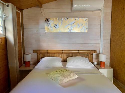 圣安德烈Les îlots du soleil levant的一间卧室配有一张带两个白色枕头的床