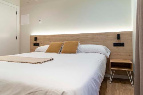 蓬特德乌梅Albatros的卧室配有一张带两个枕头的大白色床