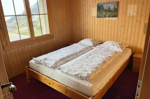 FlumsWohnung in Bergchalet的木制客房的一张床位,设有窗户
