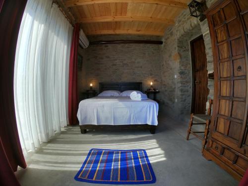 PotamósHill's Barbacane的一间卧室设有一张床和一个大窗户
