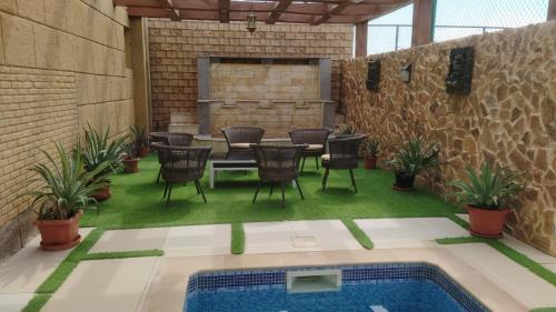 拜尔卡AlZaeem Resort & Hotels的一个带桌椅的庭院和一个游泳池