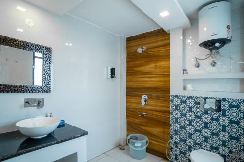 古尔冈FlxHo Uno - Serviced Apartment & Rooms - Golf Course Road的一间带水槽和木门的浴室