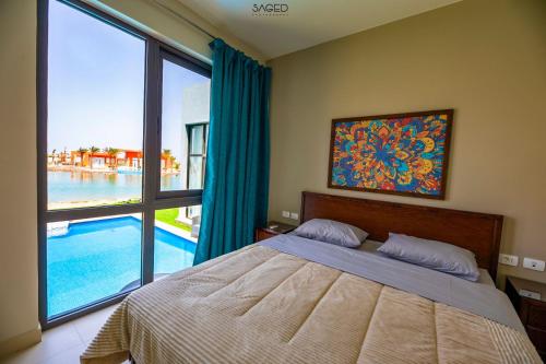 赫尔格达tawila t1-17 -5 bed room big villa的一间卧室配有一张床,享有游泳池的景色