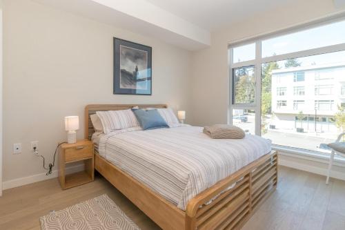 SaanichtonHaro Heights的一间卧室设有一张床和一个大窗户
