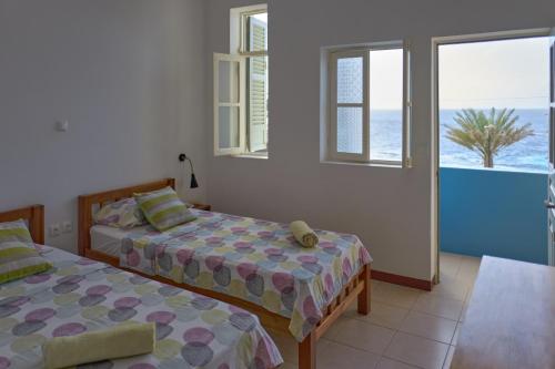 蓬塔杜索尔Música do Mar的一间带两张床的卧室,享有海景