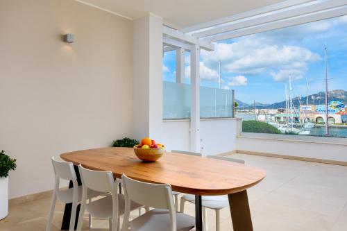 奥尔比亚Olbia Luxury Apartment的窗户客房内的一张木桌和椅子