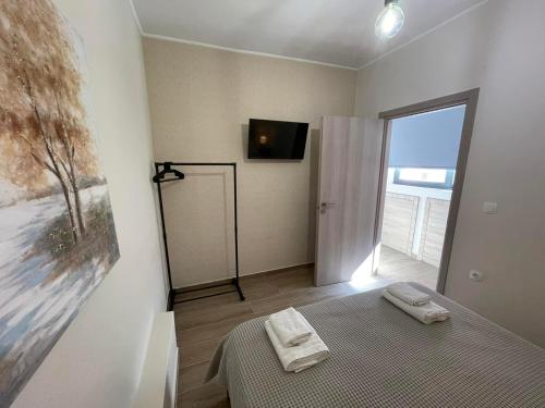 马科普隆AVR Airport Deluxe Suites 6的一间卧室配有一张床,墙上配有电视