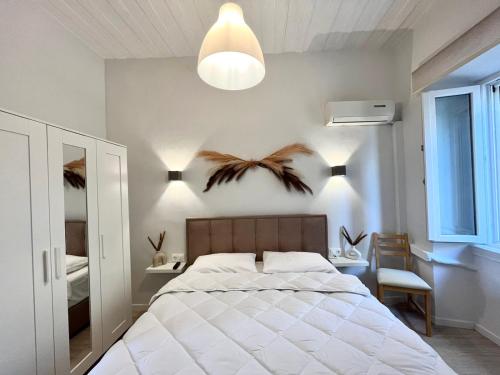 科孚镇Nenas Volto Apartment的卧室配有白色大床和灯