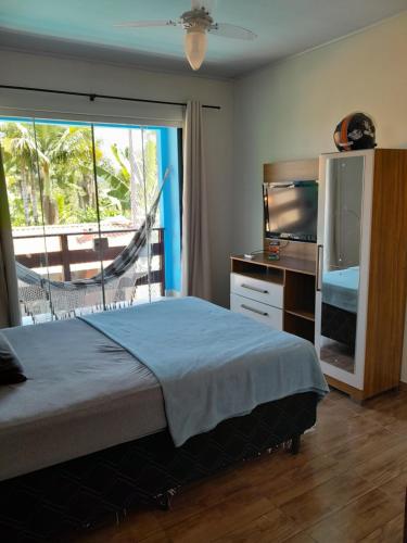 南圣弗朗西斯科Cabana Carambu的一间卧室设有一张床、一台电视和一个窗口。