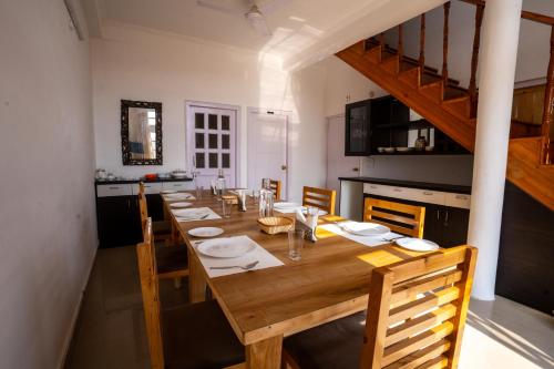 比姆塔尔Brown Stone Villa的一张带椅子的长木桌子和一间厨房