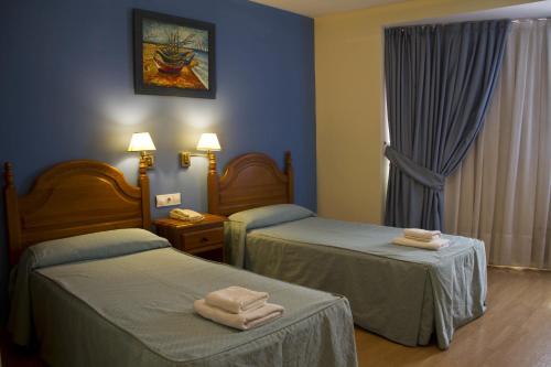 巴尔巴斯特罗克莱门特酒店的两张位于酒店客房的床,配有毛巾
